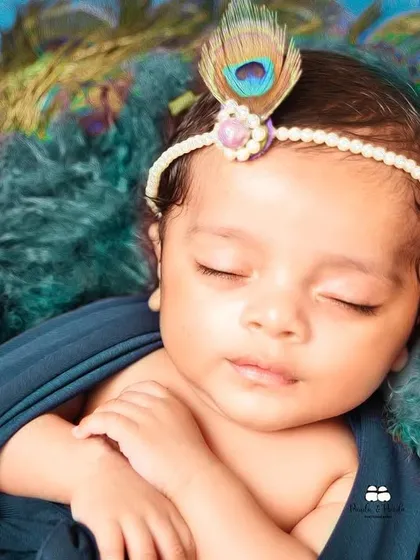 A close-up of a sleeping 28-day-old newborn during his themed photoshoot. We handle our tiniest clients with the utmost care, ensuring every session is safe, calm, and peaceful.