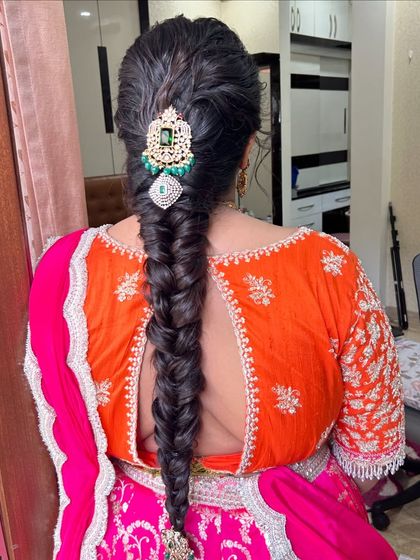 A classic fishtail braid given a traditional touch with a large, stone-studded hairpiece. This style combines modern and traditional elements perfectly.
