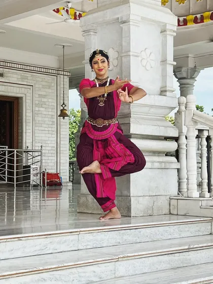 A classic Bharatanatyam pose captured on the steps of a temple during a SPIC MACAY tour. The architecture and serene atmosphere of such locations provide a stunning natural backdrop for dance.