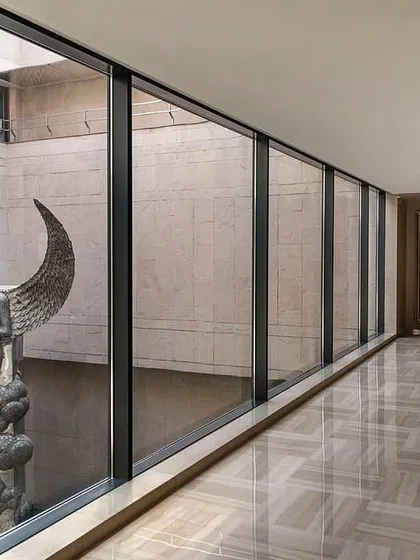 The second-floor corridor provides a stunning vantage point of the courtyard sculpture, framed by the clean lines of the window and the polished marble floor.