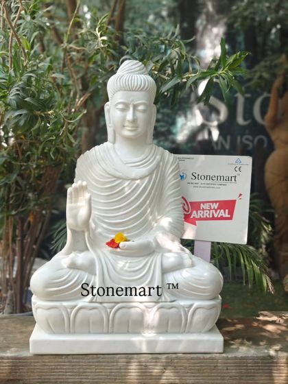 A closer view of the 3-foot white marble Buddha, showcasing the delicate carving of the facial features and the folds of the robe. Each statue is hand-carved from a single block of stone.