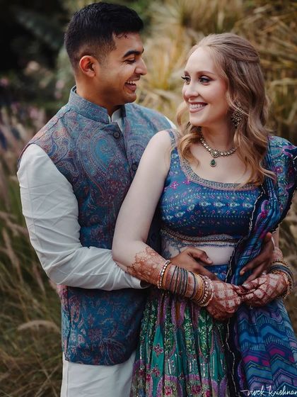 A duplicate of 197, this image captures the couple's happy interaction and the bride's lovely henna.