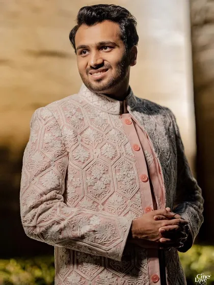 A close-up of the groom's pink and white sherwani for the Godh ceremony. The intricate threadwork and elegant design make for a stunning and sophisticated look.