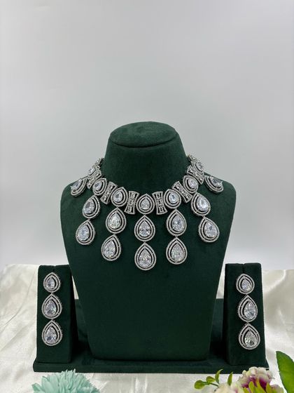 A modern necklace set with large, teardrop-shaped stones in a cascading design. This piece is available in several colors, including pink, green, and red, offering a bold and stylish look.