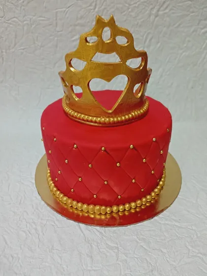 A bold red and gold cake with a crown topper. The quilted pattern and rich colors give it a regal and luxurious feel.