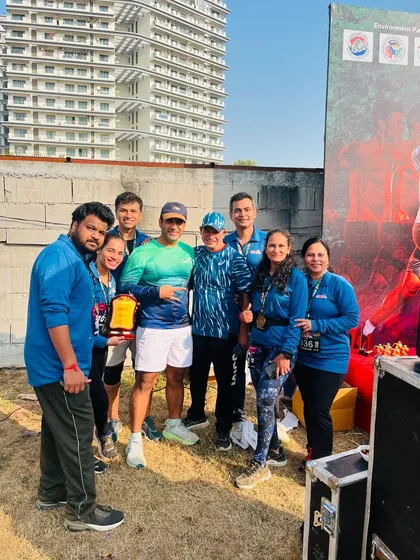 Posing with a group of runners and their trophy after the Aravali Trail Run. Team achievements are a special focus for us.