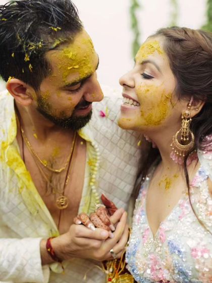 A happy, candid moment between the couple during their Haldi ceremony. Her makeup stays put even with all the haldi application.
