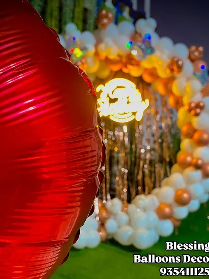 Another detail shot of the outdoor birthday arch, showing the "Happy Birthday" neon sign glowing as night falls. The shimmer wall behind it adds a touch of glamour.
