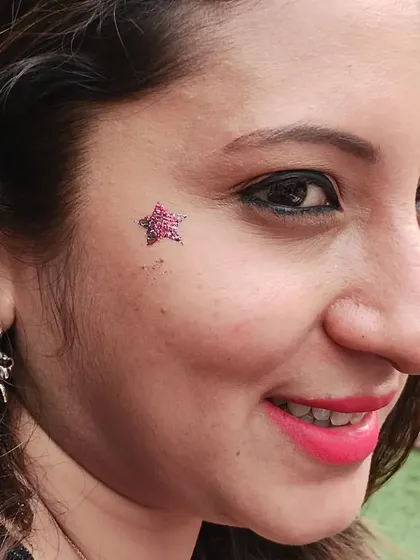 My body art isn't just for kids. Adults love adding a bit of sparkle too. This subtle yet elegant star glitter tattoo on the cheek is perfect for adding a festive touch to any grown-up event or celebration.