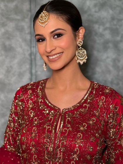 A close-up on the bold yet soft eye makeup, paired with a natural lip, making the maroon outfit the star of the show.