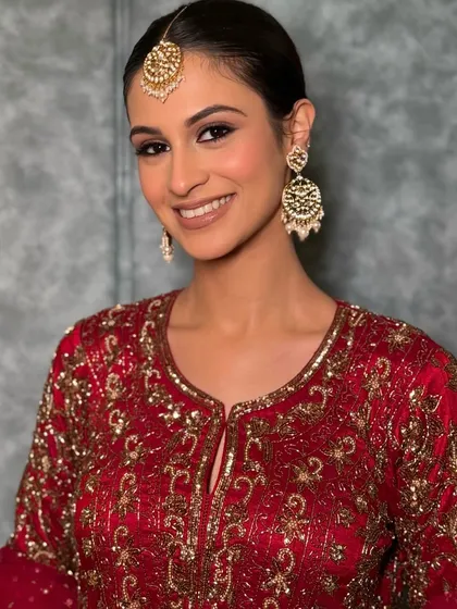 A close-up on the bold yet soft eye makeup, paired with a natural lip, making the maroon outfit the star of the show.