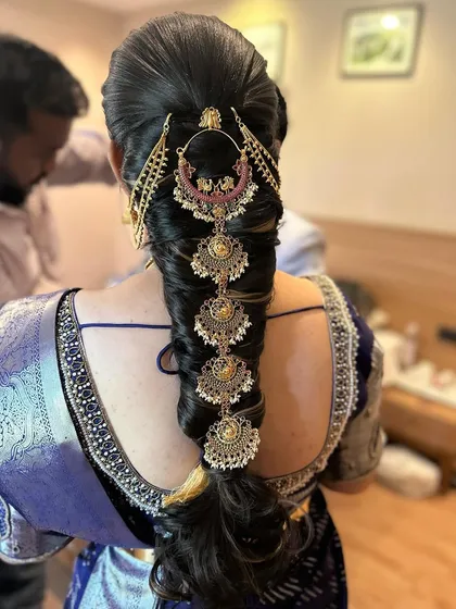 An elegant engagement look featuring a messy braid adorned with large, traditional jewellery. This hairstyle is a perfect blend of modern and classic styles.