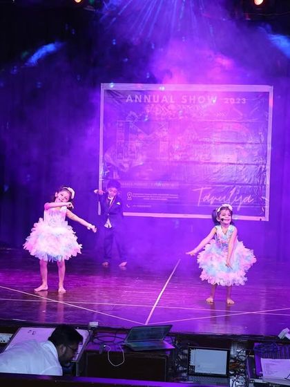 The stage is filled with purple light and bubbles for this enchanting kids' performance.