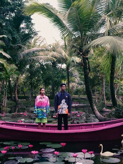 A surreal scene from the 'All Beneath Heaven' campaign. We placed models in a pink boat on a lily pond, creating a dreamlike image that blends fantasy with nature.