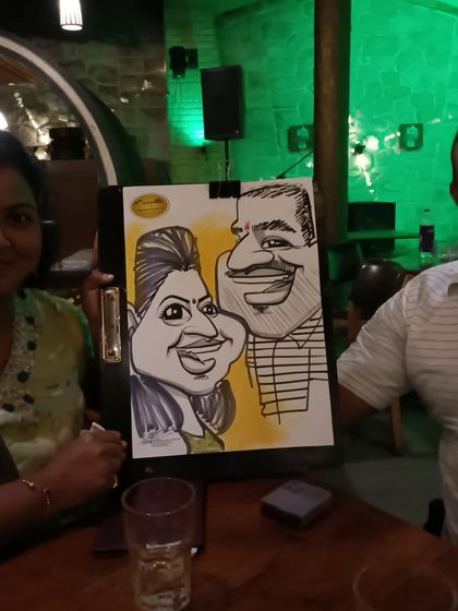 Another couple enjoying their caricature souvenir from their dinner.