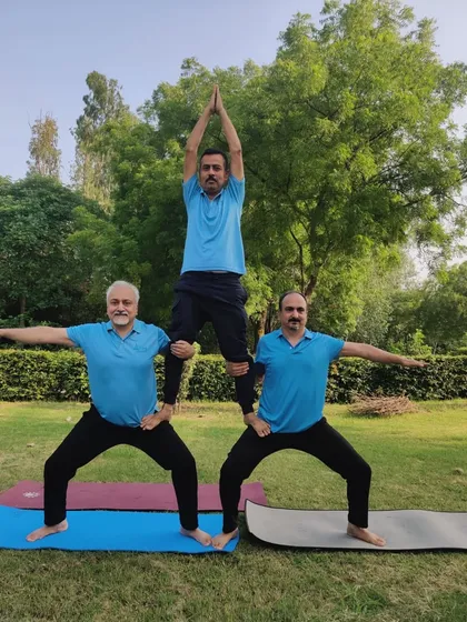 A three-person acro yoga pyramid during our outdoor session on International Yoga Day. This demonstrates incredible strength, balance, and teamwork.