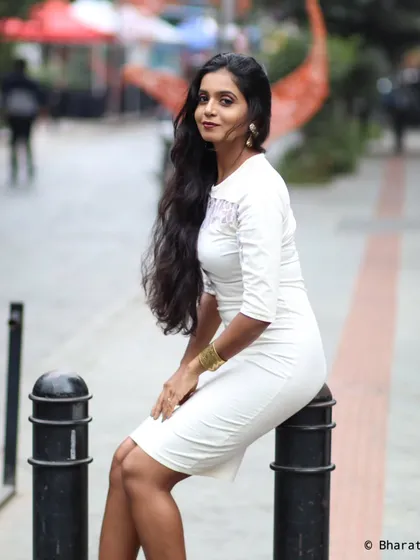 A seated pose on a city bollard, giving the elegant white dress a slightly more casual and spontaneous feel.