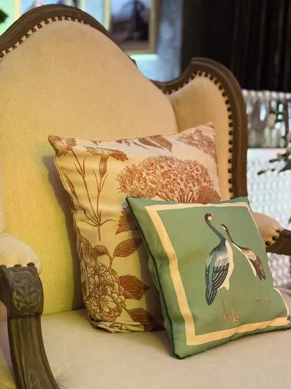 A close-up of custom-printed cushions with floral and bird motifs, showcasing our ability to create bespoke soft furnishings to match any theme.