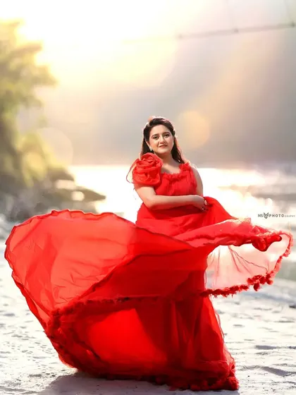A stunning pre-wedding portrait session by the river in Rishikesh. The flowing red gown against the natural, sunlit backdrop creates a dramatic and romantic image, perfect for couples who want a fairytale-style photoshoot.