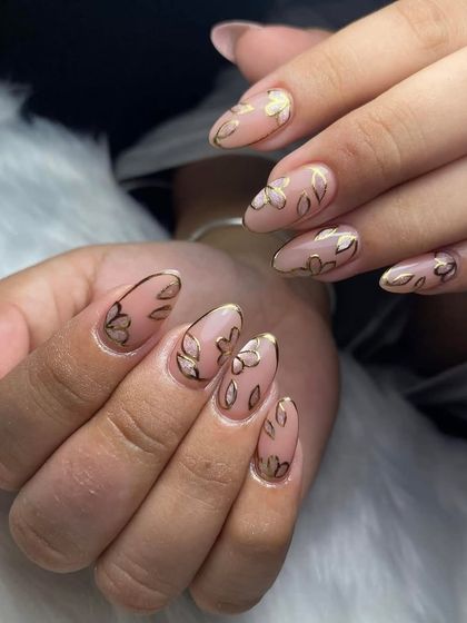 A full set of nude nails with gold floral outline art. This minimalist yet detailed design is very popular and chic.