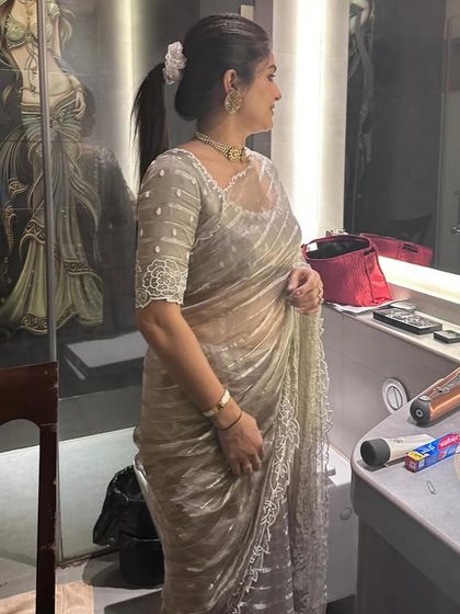Sahana looks absolutely gorgeous in this organza saree. I designed the blouse with delicate beadwork and sheer sleeves for an elegant, understated look perfect for an evening event.