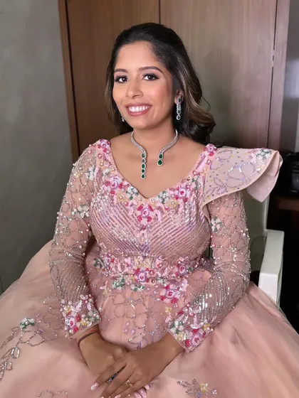 A princess-style Sangeet look with long, flowing curls and a statement bow accessory.