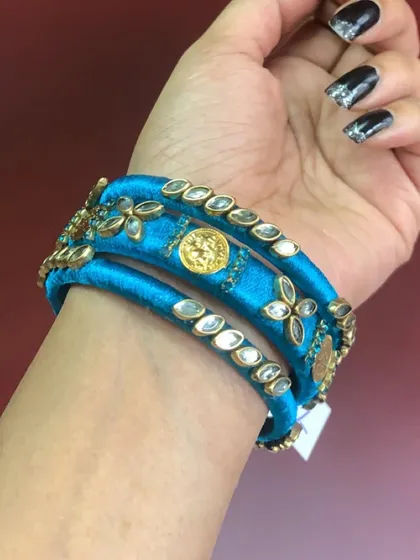 Explore my range of blue silk thread bangles, featuring different styles with kundan stones, coins, and pearl embellishments.