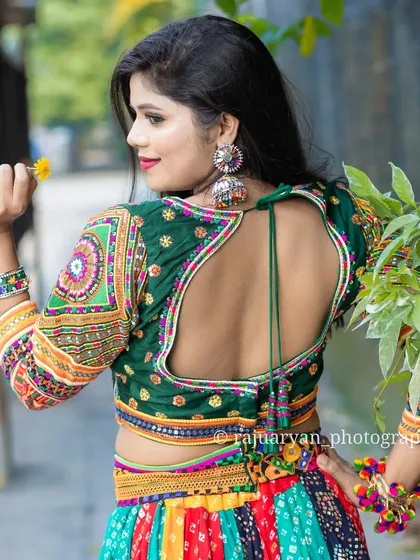 It's all in the details. We design our Navratri chaniya cholis with beautiful, traditional craftsmanship, like the intricate back design on this handmade blouse, ensuring you look great from every angle.