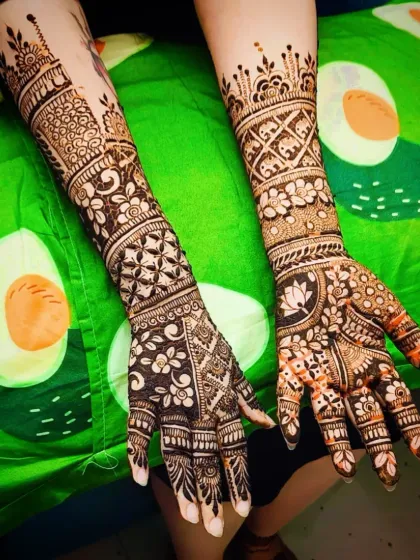 The full view of another stunning engagement mehandi, with a lotus motif on one hand and dense floral work on the other.