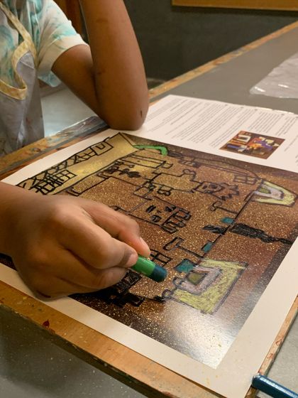 A close-up of a student coloring in their Picasso-inspired drawing, learning about shape and composition.