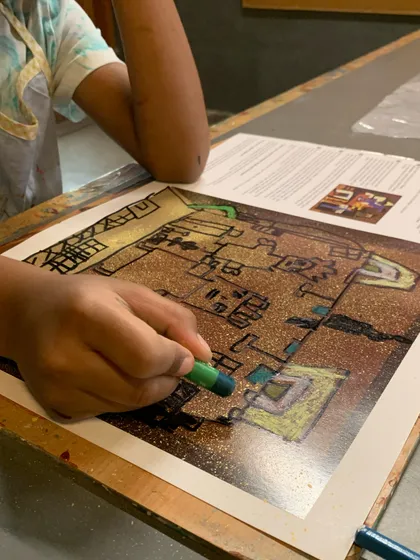 A close-up of a student coloring in their Picasso-inspired drawing, learning about shape and composition.