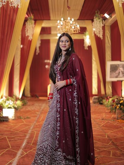A full-length shot of the client in her maroon chevron lehenga, showing the beautiful drape of the dupatta.