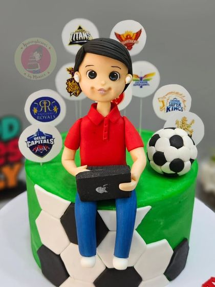 A close-up of the figurine for a football and IPL fan, complete with his laptop and AirPods.
