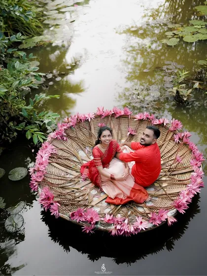A unique aerial-style shot of the couple in a traditional coracle boat decorated with flowers, offering a breathtaking perspective.