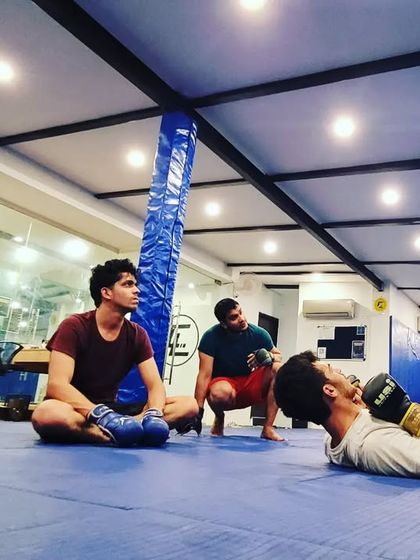 Learning MMA from the best. A coach demonstrates a striking technique to a small group, ensuring each student understands the fine details of the movement.