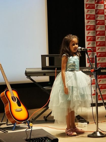 One of our youngest performers confidently takes the stage for a solo vocal performance at the Thane music showcase. We believe in nurturing talent from a young age and giving every student their moment in the spotlight.