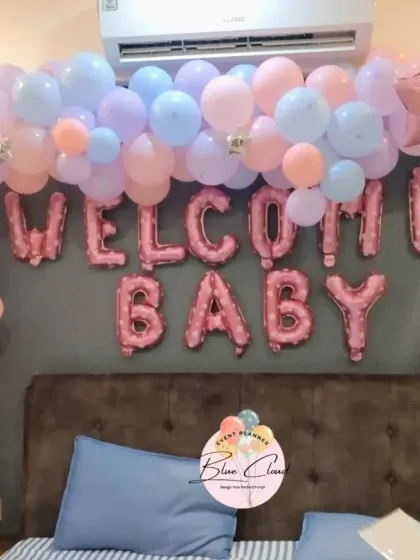 A beautiful pastel pink and blue 'Welcome Baby' decoration over a bed, creating a soft and dreamy atmosphere.