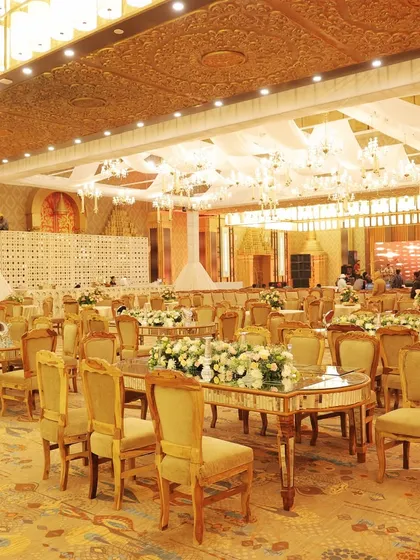 A luxurious dining area with mirrored tables that reflect the light from the grand chandeliers, enhancing the opulence of the space.