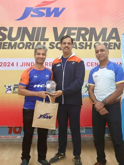 Receiving my semi-finalist trophy at the JSW Squash Open. Every tournament is a learning experience, and I bring those lessons back to my students.