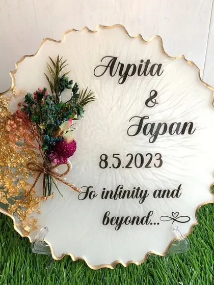 A clean and elegant frame for a couple, featuring their names, a special date, and a preserved floral bouquet.