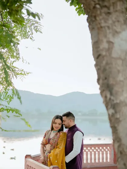 An intimate embrace under a tree, with the tranquil Jal Mahal in the distance. This shot combines natural beauty with iconic architecture for a perfect romantic portrait.
