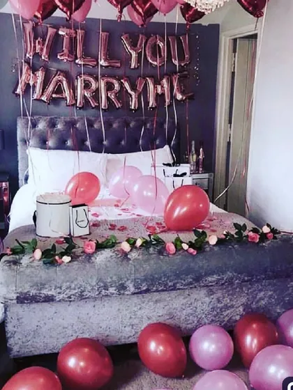 I can help you ask the big question with a complete proposal room setup. This decoration includes "WILL YOU MARRY ME" foil balloons above the bed, a romantic rose garland, and color-coordinated balloons to fill the space.