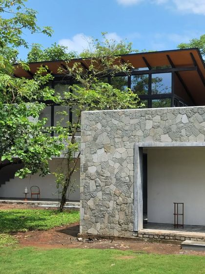 The stone and glass facade of 'Villa 16'. The bedrooms are suspended in the tree canopies, rooting the home to its site in every way.