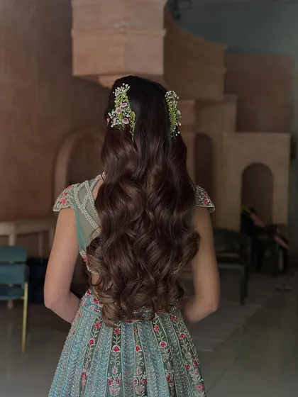 For a soft and romantic pre-wedding look, I created these beautiful, uniform waves using extensions for added length and volume. The style is finished with small, fresh floral clips, making it ideal for an engagement or Sangeet ceremony.