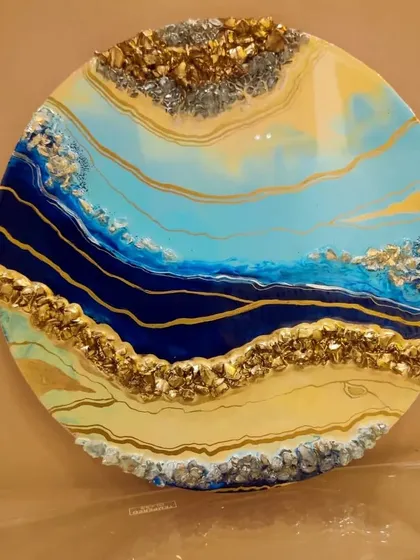 Another view of the vibrant blue and gold abstract resin wall art. The layers of color and texture from the crystals create a sense of depth and luxury.
