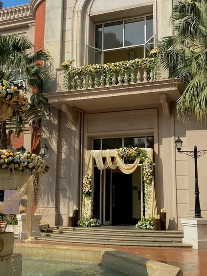 This is how I transform a venue's entire exterior. For this event, I decorated the main entrance, the balcony, and the fountain area with elegant white and yellow floral arrangements.
