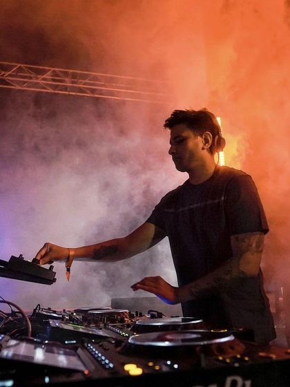 A DJ performs amidst a cloud of atmospheric smoke and dramatic lighting. I use a combination of light and fog to create a mysterious and immersive mood.