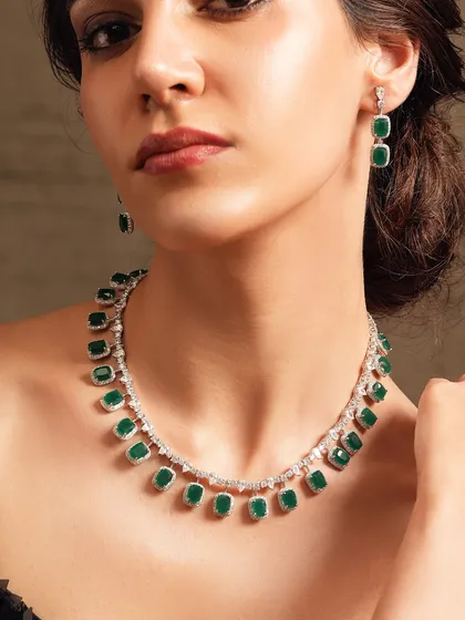 A delicate diamond chain necklace with square-cut emerald drops, perfect for a sophisticated cocktail look.