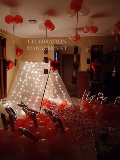 This view shows the inside of the fairy light tent, filled with balloons and surrounded by a carpet of rose petals. It’s a perfect little bubble of celebration for two.