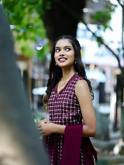 A candid portrait of a young woman in traditional wear, taken in a natural outdoor setting. This style creates a relaxed and authentic feel.